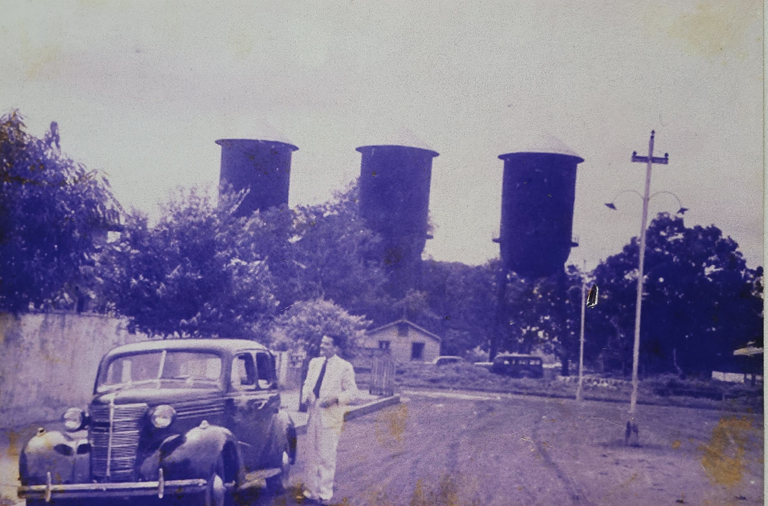 Foto antiga do centro de Porto Velho, com as caixas d'água ao fundo e um carro dos anos 40