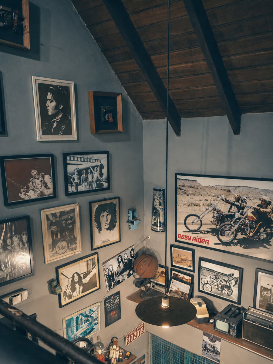 Parede de quadros da barbearia, com a luminária pendente